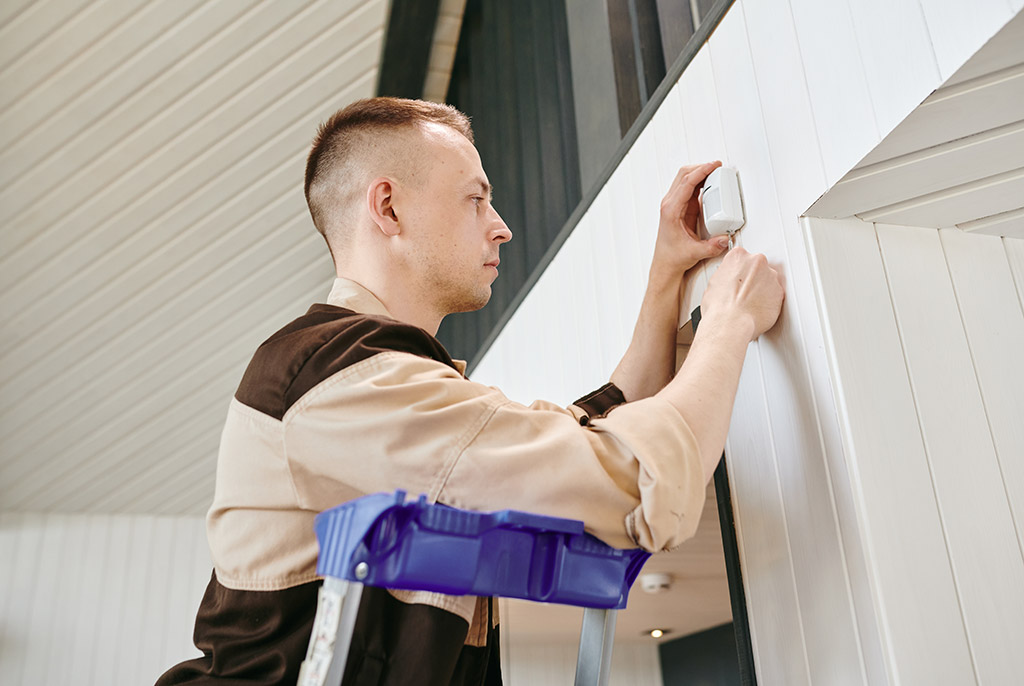 Man installing alarm system in home for security
